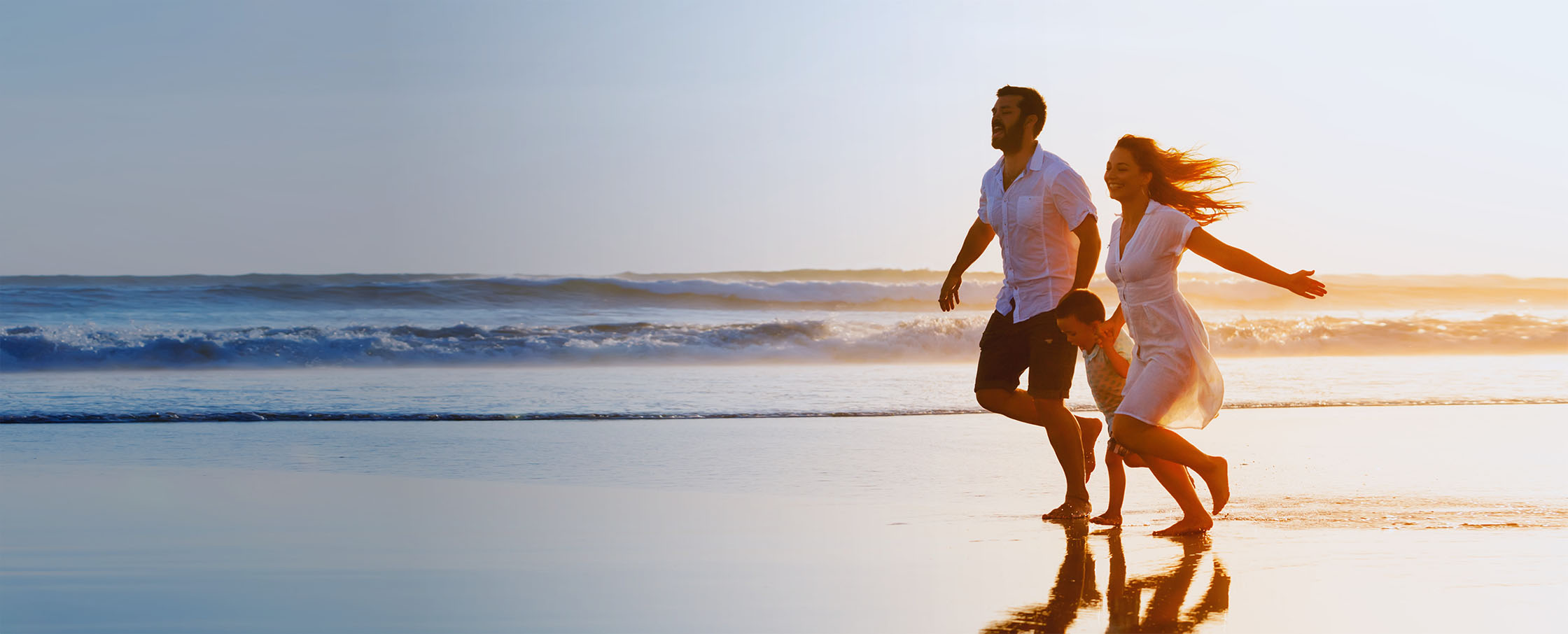 Family running in the beach
